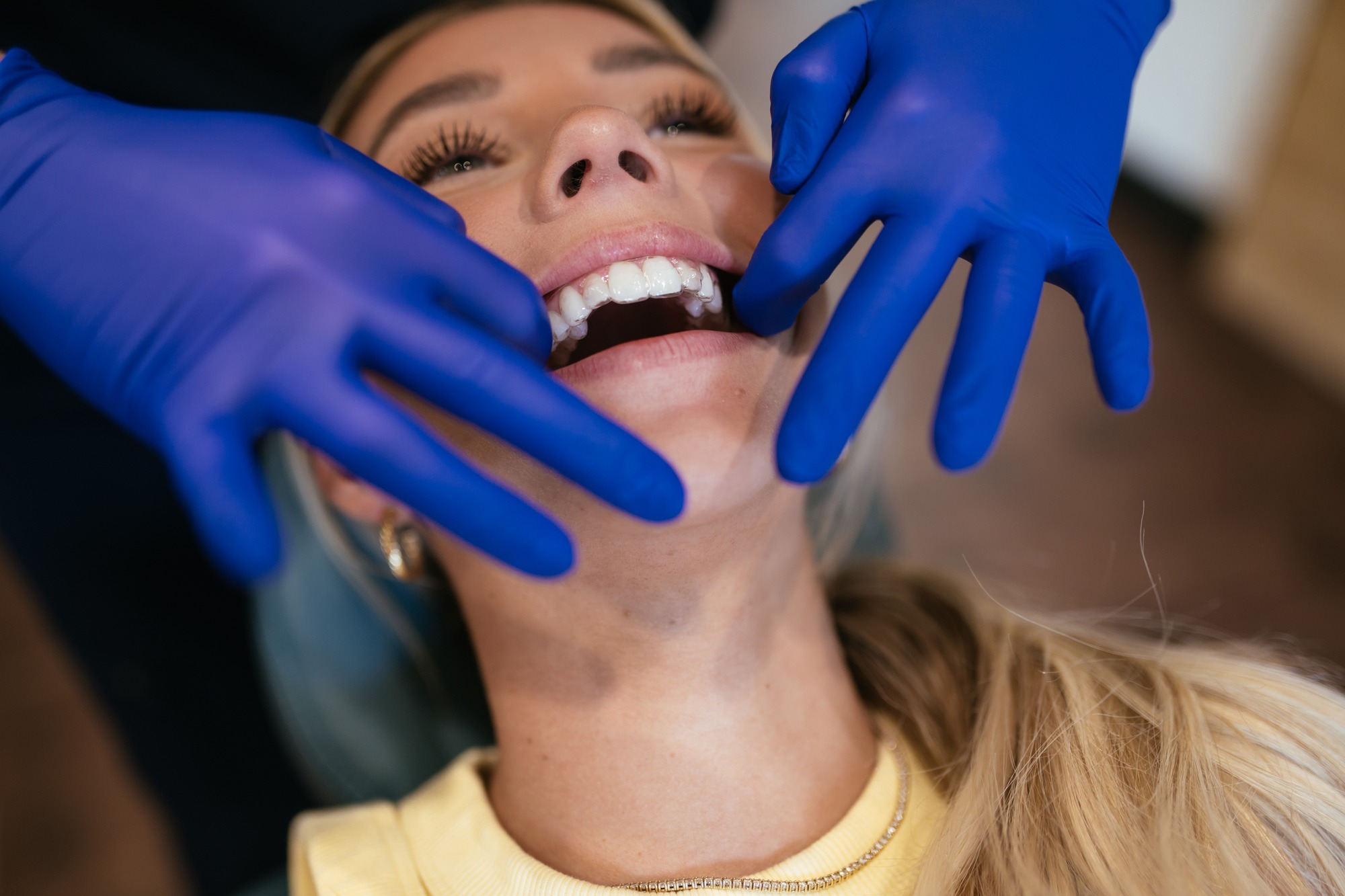 Orthodontist adjusting clear Invisalign aligners on a smiling patient during an appointment at Sturgill Orthodontics in Johnson City, TN.