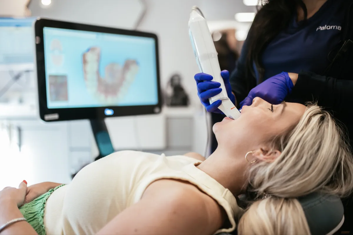 Sturgill Orthodontics team member taking a digital 3D scan of a patient's teeth, with the scan showing on the screen